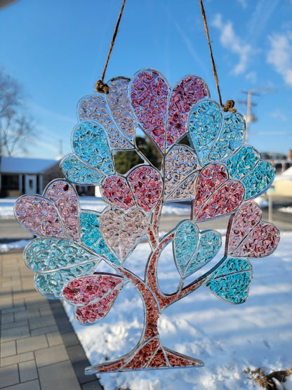 Decorative tree with pink and blue heart-shaped  leaves against a blue sky.