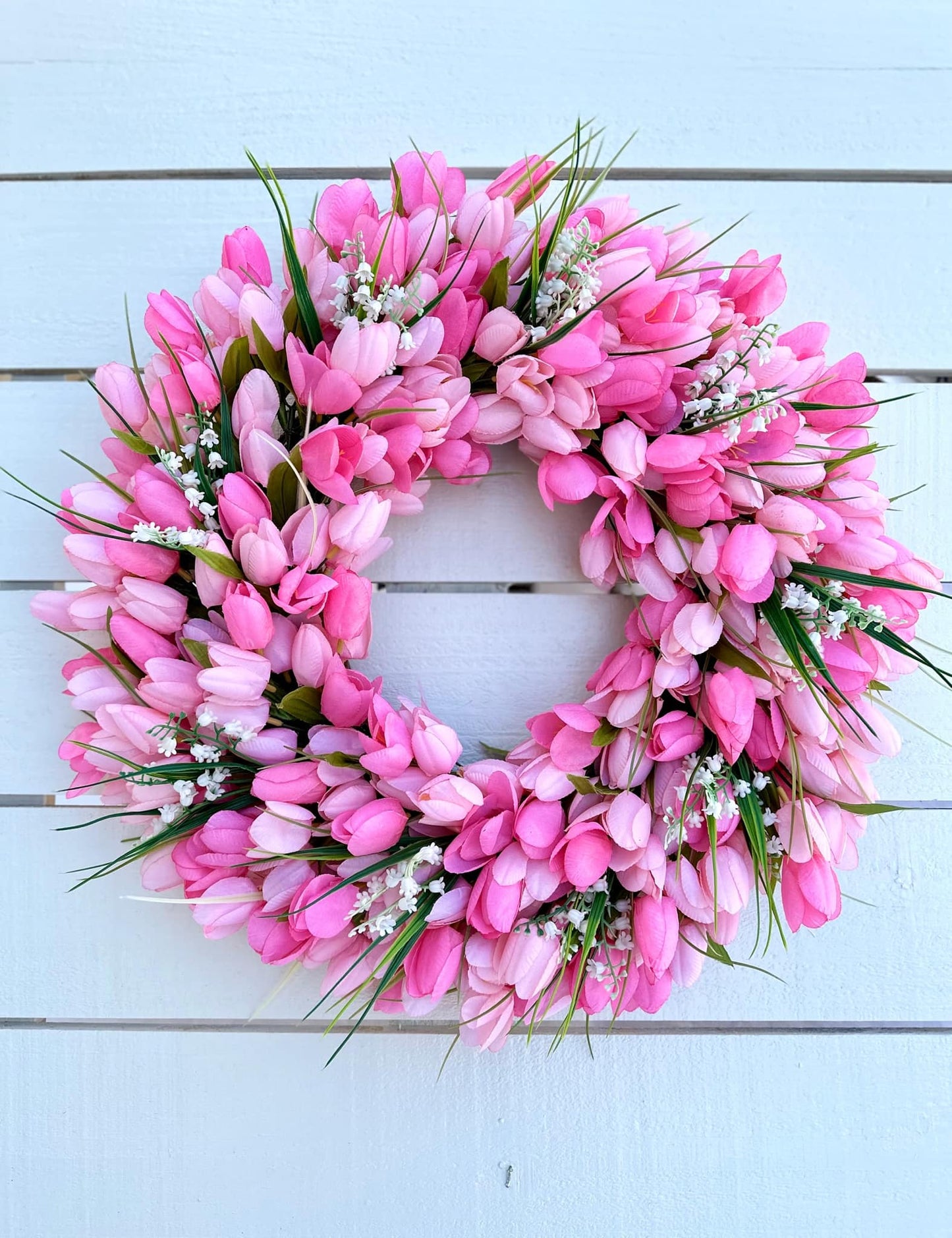 Pink tulip wreath on a wooden background