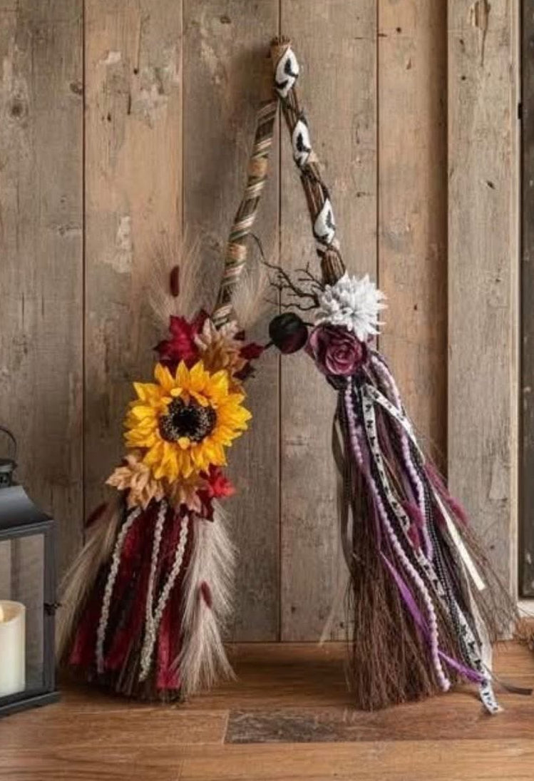 Boho-style autumn wreath and decorative hanging decor displayed on a rustic wooden door and wall, with a lantern, doormat, and weathered wood door in the background.