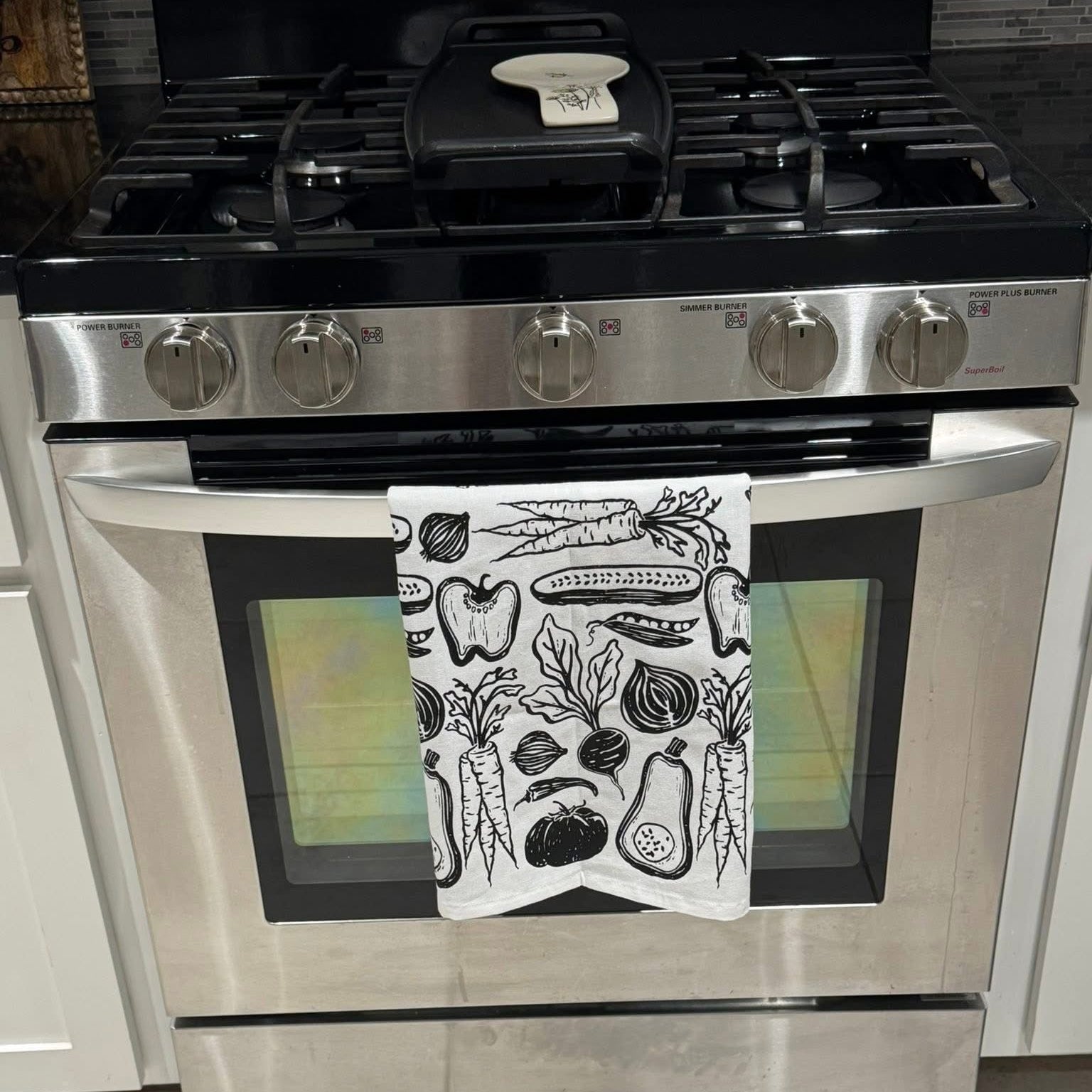 Stainless steel oven with a decorative towel on the door