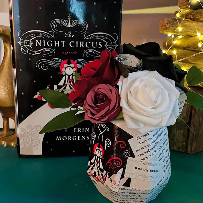 Book titled 'The Night Circus' with a bouquet of roses on top