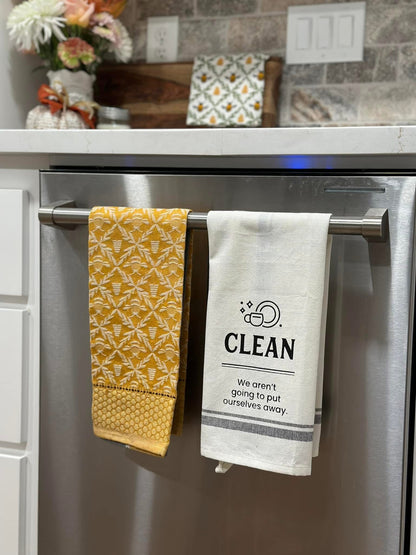 Yellow patterned towel and 'Clean' white towel hanging on a kitchen towel rack.