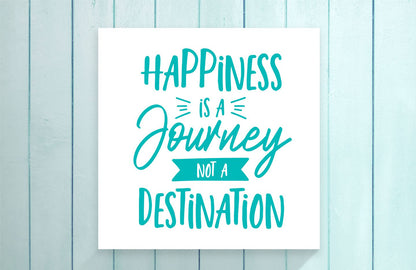 Motivational poster with 'Happiness is a Journey, Not a Destination' text on a light blue wooden background.