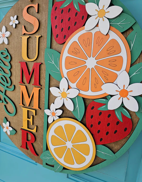 Decorative wall art with 'SUMMER' text, oranges, strawberries, and flowers on a blue background.