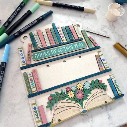 Decorative board with 'Books Read This Year' text on a marble surface with markers.