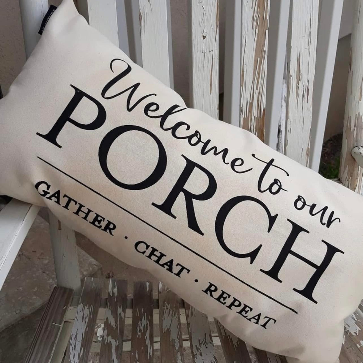 Decorative pillow with 'Welcome to our Porch' text on a wooden bench.
