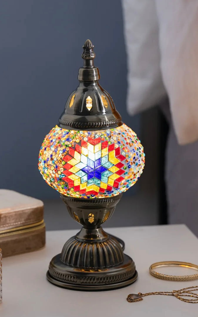 Decorative mosaic lamp with multicolored design on a table