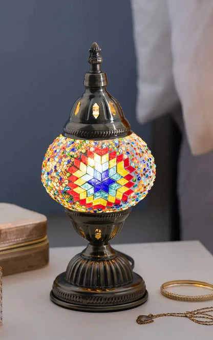 Decorative mosaic lamp with multicolored design on a table