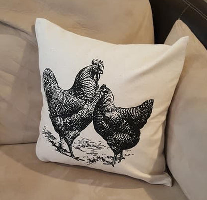 Decorative pillow with black chicken illustration on a beige couch