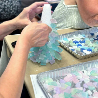 Children making a craft with colorful foam pieces on a table.