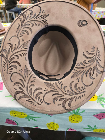 Decorative hat with intricate patterns on a colorful tablecloth.