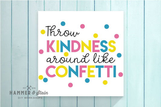 Motivational poster with colorful text 'Throw kindness around like confetti' on a light blue wooden background.