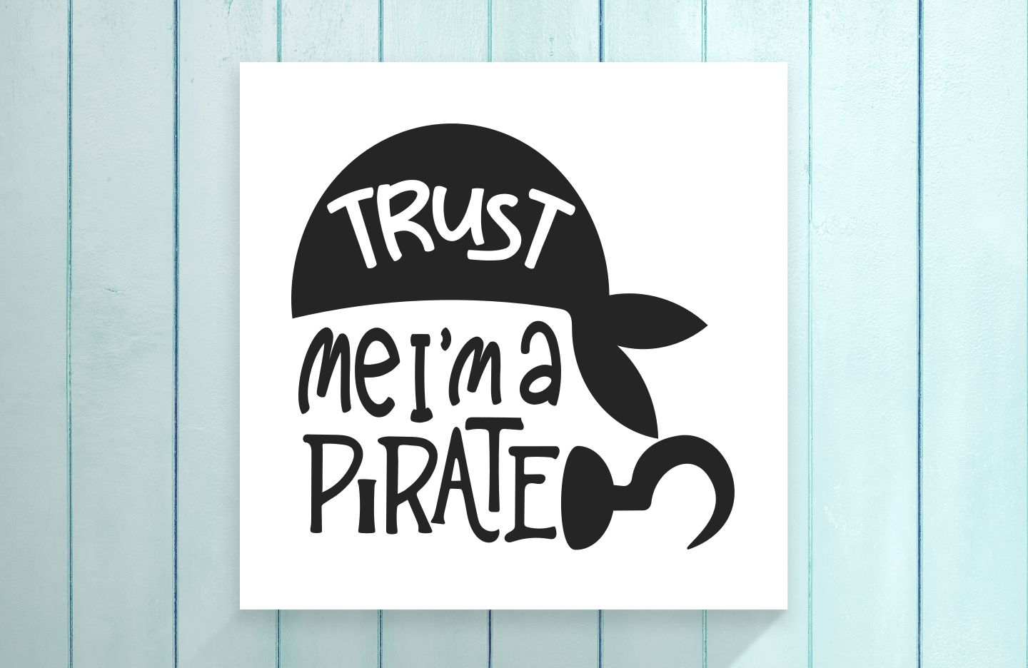 Sign with 'Trust me, I'm a pirate' text on a light blue wooden background