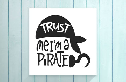 Sign with 'Trust me, I'm a pirate' text on a light blue wooden background