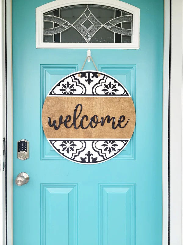 Turquoise door with a decorative 'welcome' sign hanging on it