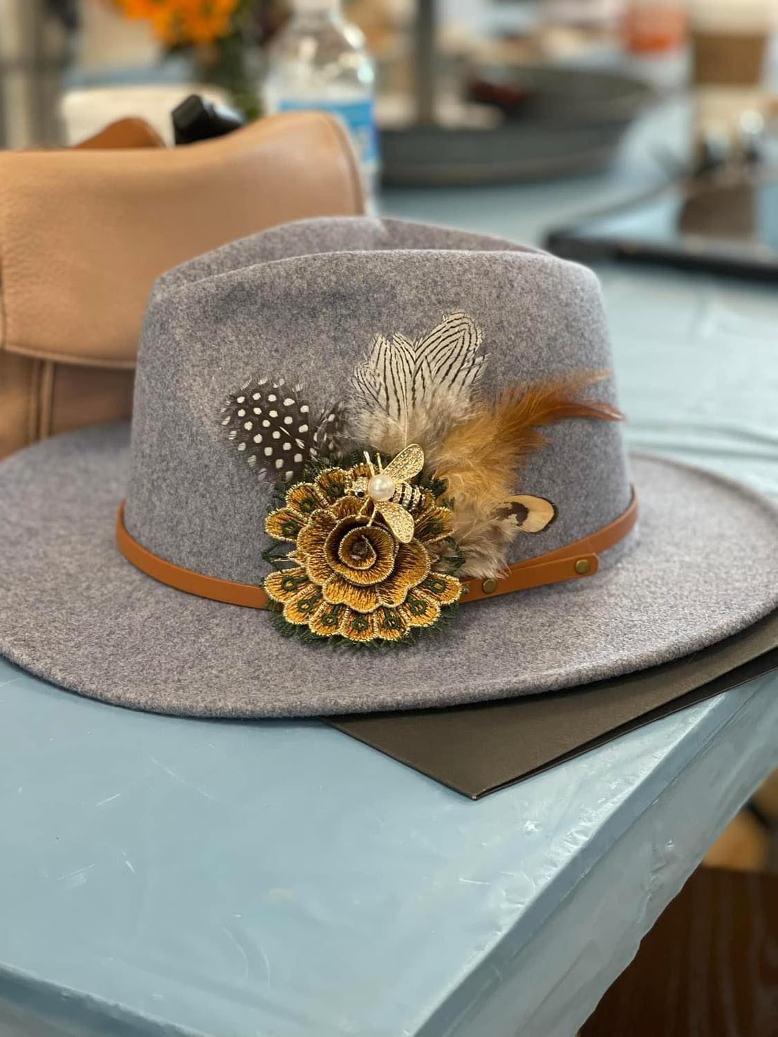 Gray fedora hat with decorative elements on a table