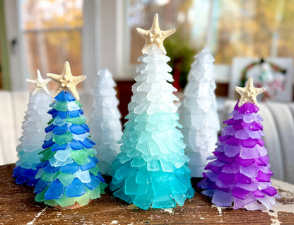 Colorful Christmas tree figurines with star-shaped ornaments on a wooden surface.