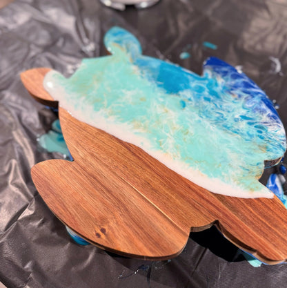 Wooden surfboard-shaped object with blue and white design on a black surface